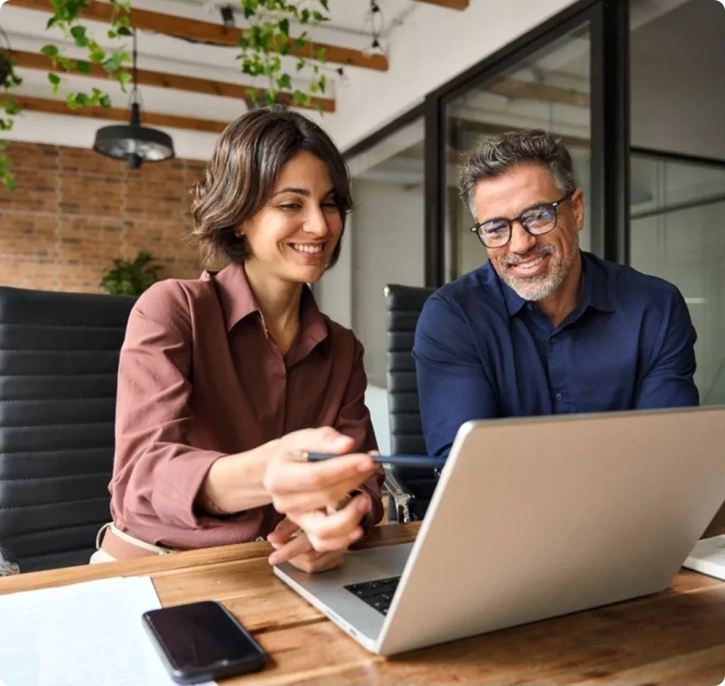 Accountants reviewing financial reports together around a laptop